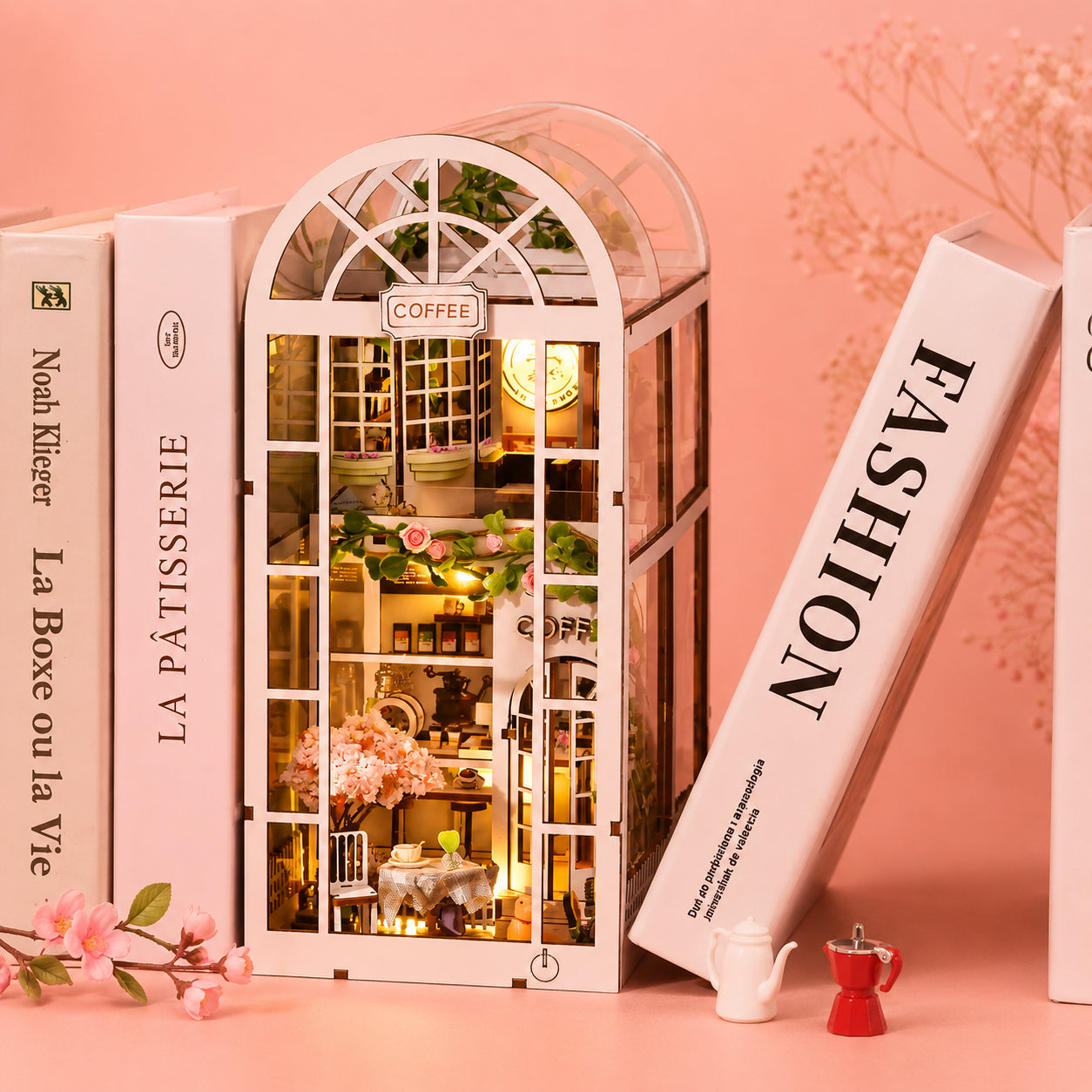 Book Nook Café au Jardin kit DIY miniature LED posé entre des livres 